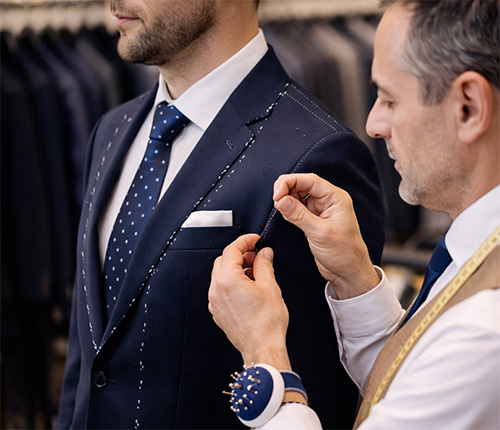 Dorset wedding tailors adjusting a groom’s custom suit in a boutique