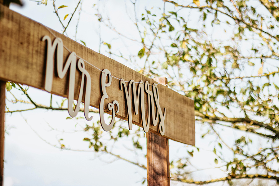 Rustic wooden Mr and Mrs wedding sign decoration at outdoor UK wedding
