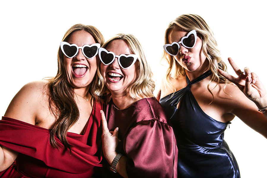 Guests wearing heart shaped glasses enjoying a wedding photo booth in Hampshire