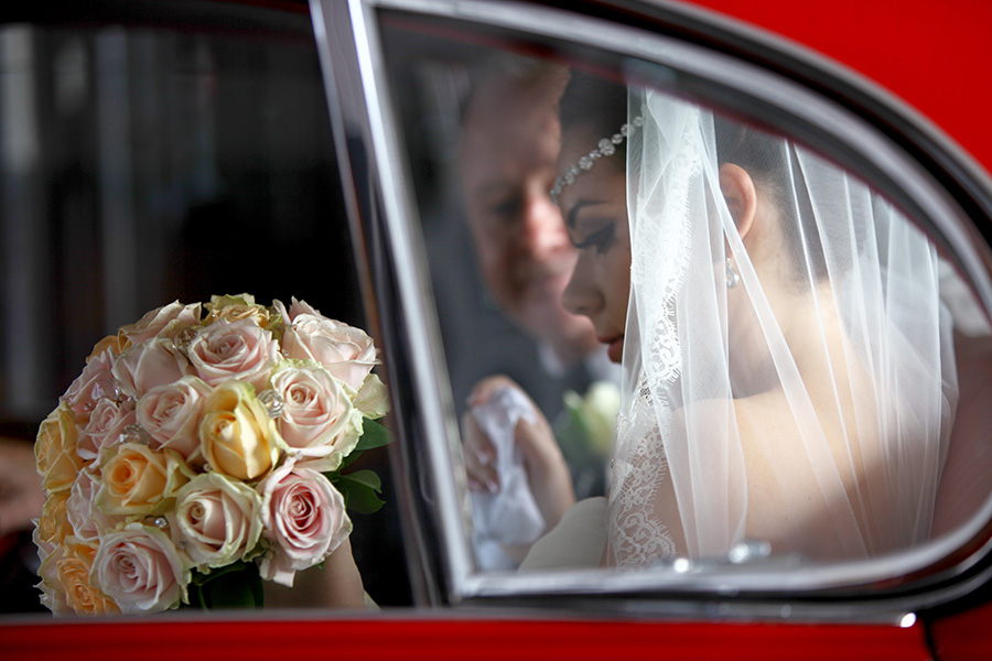 Bride arriving in classic wedding car Dorset