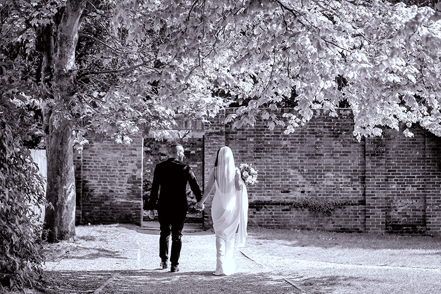 Couple walking through garden at a country house wedding venue in DorsetA couple walking through the gardens of a country house wedding venue in Dorset