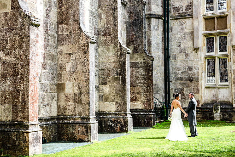 Bride and groom standing outside a stone manor at a country house wedding venue in Dorset