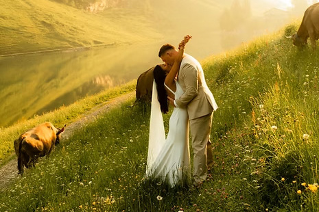 Bride and groom embracing in golden light beside a lake during romantic Dorset wedding photography session