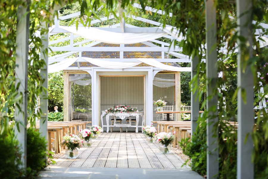 hampshire-outdoor-wedding-venue-ceremony-garden-setting Outdoor wedding ceremony setup at a Hampshire venue with floral aisle and garden surroundings