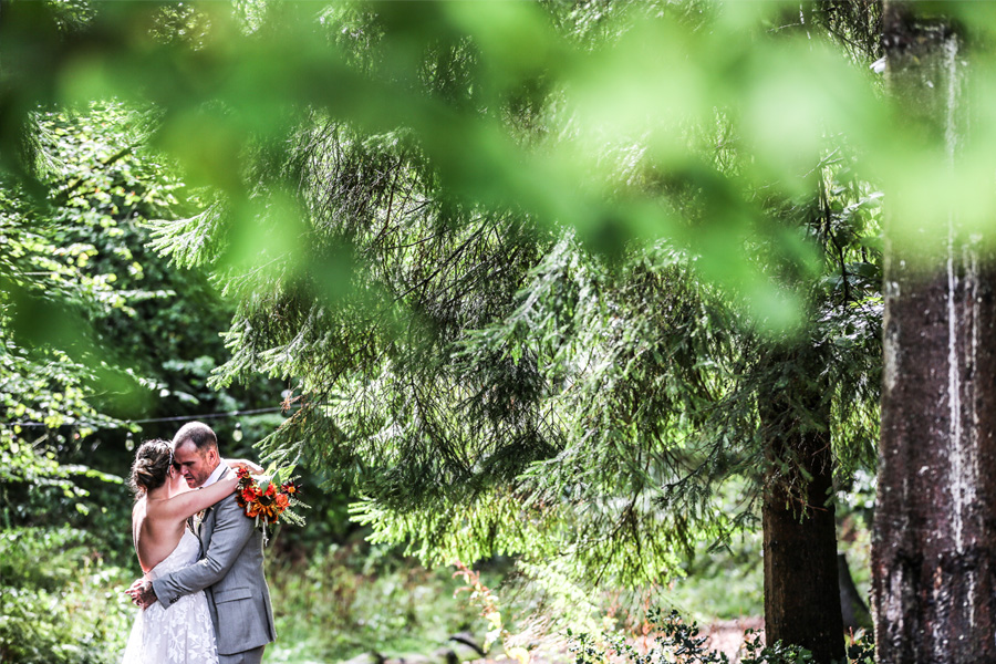 Bride and groom embracing in a forest setting at an outdoor wedding venue in Hampshire
