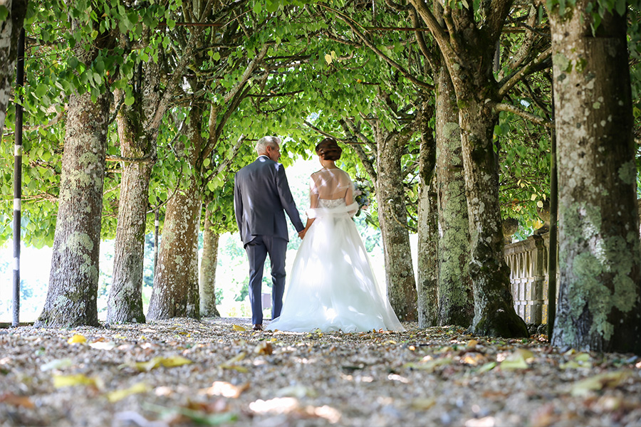 Bride and groom walking through a tree lined path at a Hampshire wedding venue