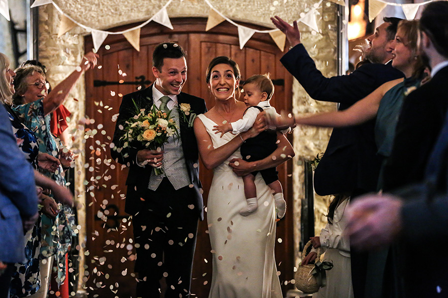 Bride and groom celebrating a wedding ceremony at Kingston Country Courtyard barn wedding venue in Dorset