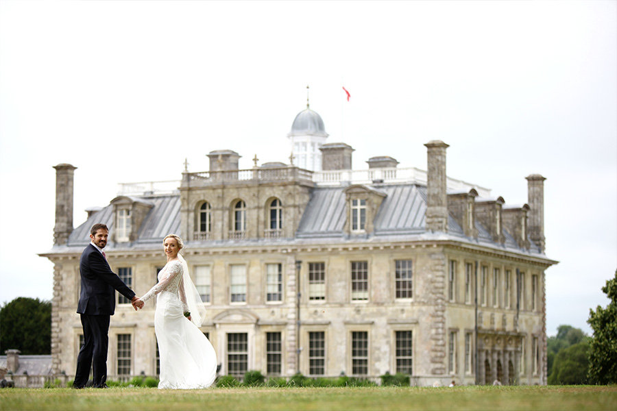Bride and groom standing in front of a stately home at a luxury wedding venue in Dorset