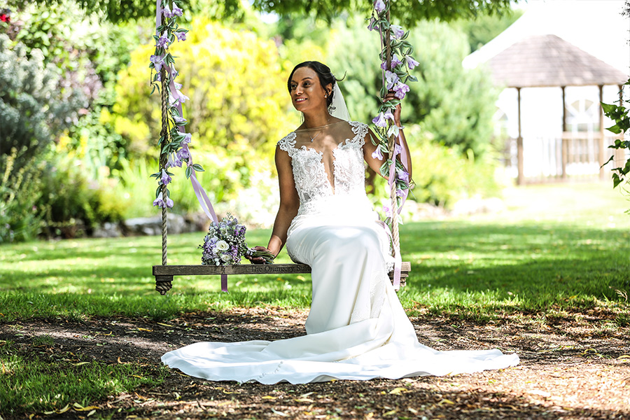 Bride on swing in garden at The Orangery Suite Wimborne Dorset wedding venue