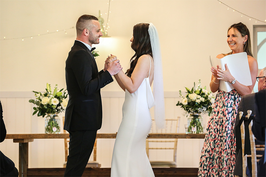Bride and groom holding hands during ceremony led by Pearly Promises wedding celebrant in Dorset