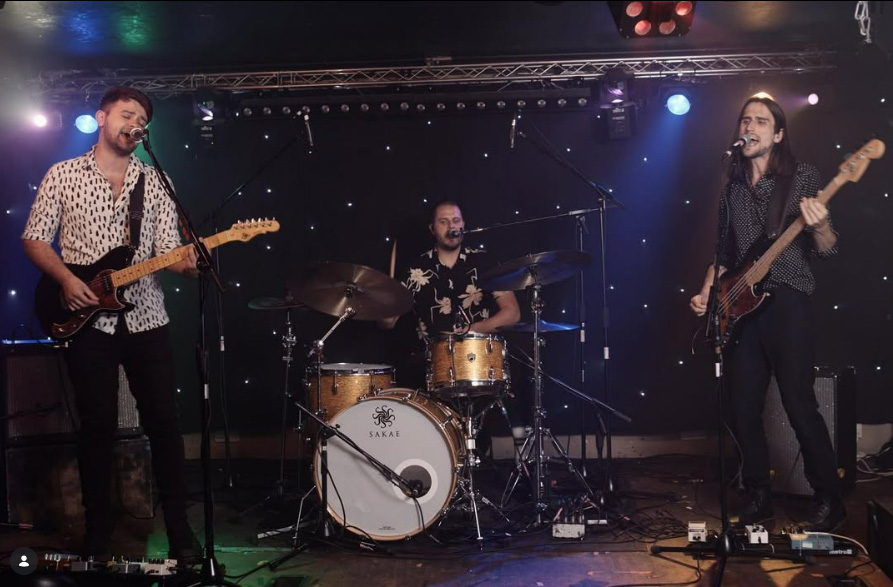 The Moonrunners performing live as a wedding band on stage with guitars and drums
