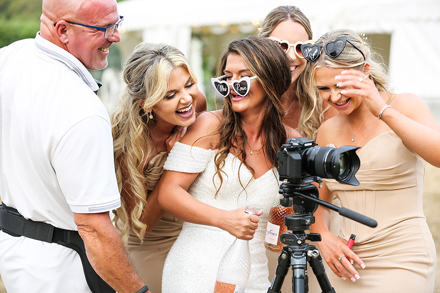 Wedding guests watching video playback with a wedding videographer at a Hampshire wedding