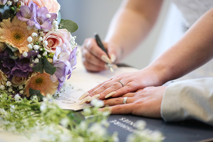 Couple signing the wedding register during their ceremony in Dorset.
