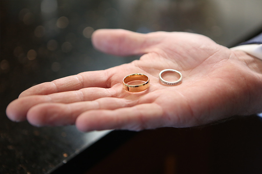 gold and silver wedding rings held in hand before legal marriage ceremony in England