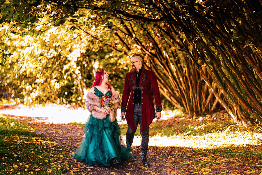 Becky Takes Photos Hampshire wedding photographer capturing colourful autumn wedding couple walking through tree lined path