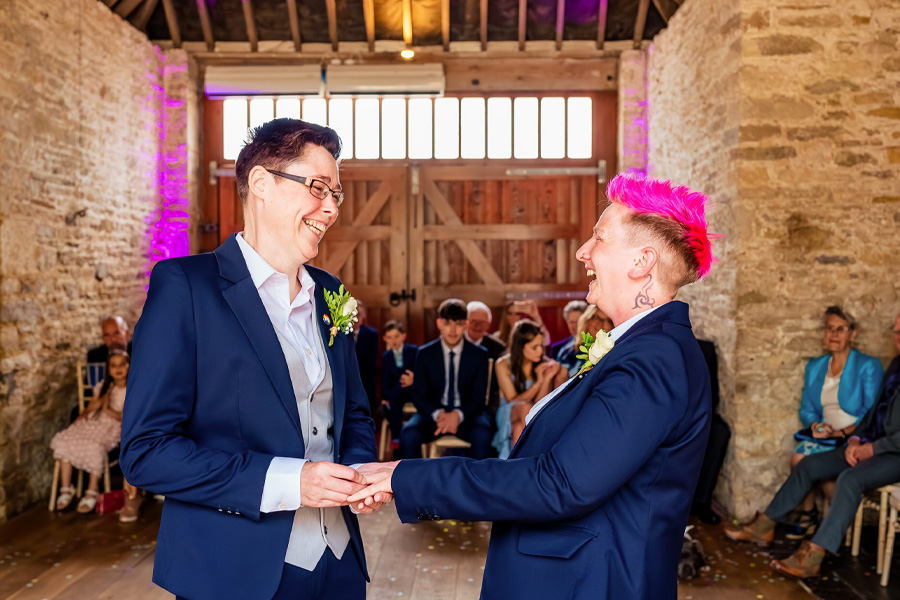 Becky Takes Photos Hampshire wedding photographer capturing joyful ceremony moment of couple exchanging vows in rustic barn