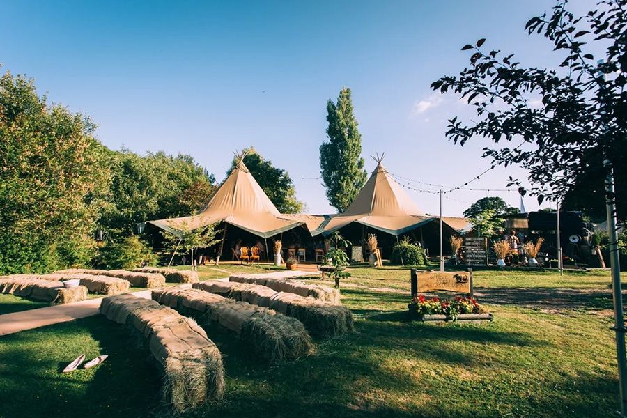 Tipi wedding setup by Coastal Tents with outdoor seating and sailcloth tents in Dorset