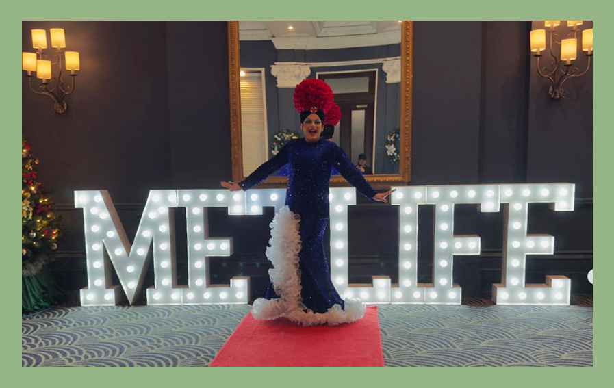 Drag wedding entertainer performing in front of illuminated LOVE letters at a wedding reception