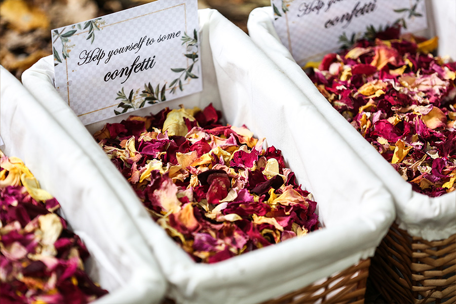 wedding confetti station with dried petals and decorative baskets