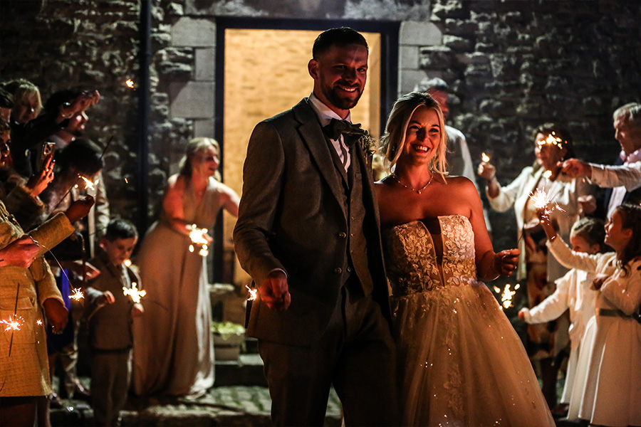 Bride and groom sparkler exit at Kingston Country Courtyard Dorset evening wedding celebration
