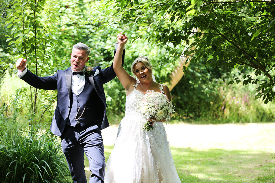 Bride and groom celebrating in garden at Kingston Country Courtyard Dorset wedding venue