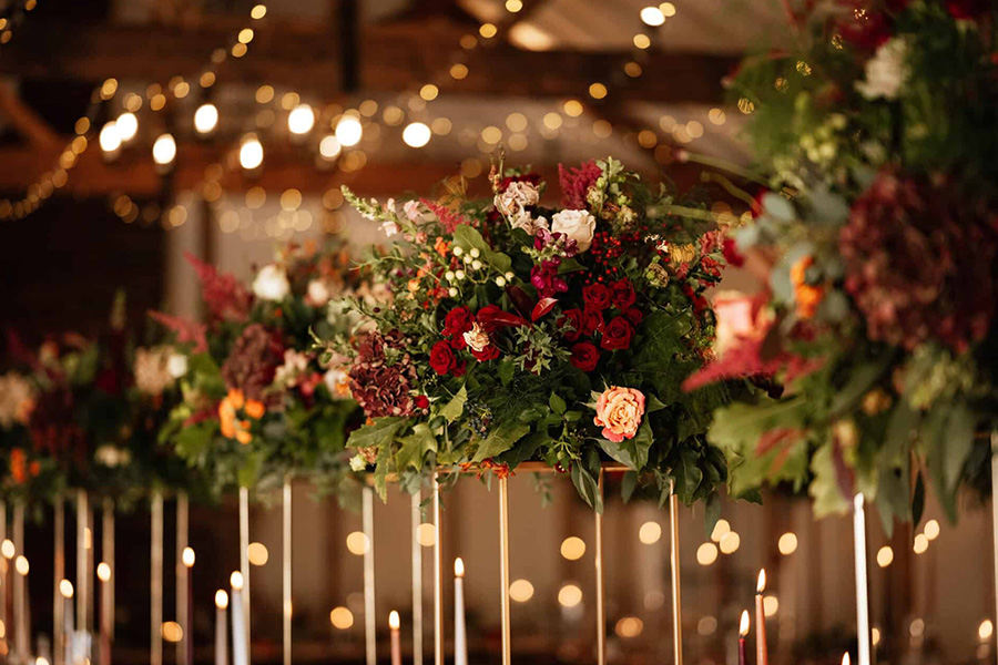 Luxury wedding floral centrepiece with candles and rich seasonal flowers in Hampshire venue