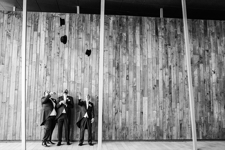 groomsmen celebrating at a luxury wedding venue in Hampshire with modern architectural backdrop