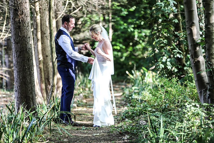 Bride and groom portrait in woodland at The Old Vicarage wedding venue Dorset surrounded by trees and greenery