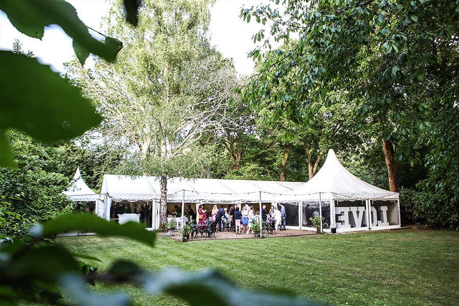 Garden marquee wedding reception at The Old Vicarage wedding venue Dorset with guests and outdoor lawn setting