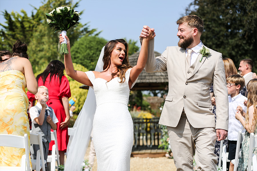 Bride and groom walking down the aisle after ceremony at The Orangery Suite Dorset outdoor wedding