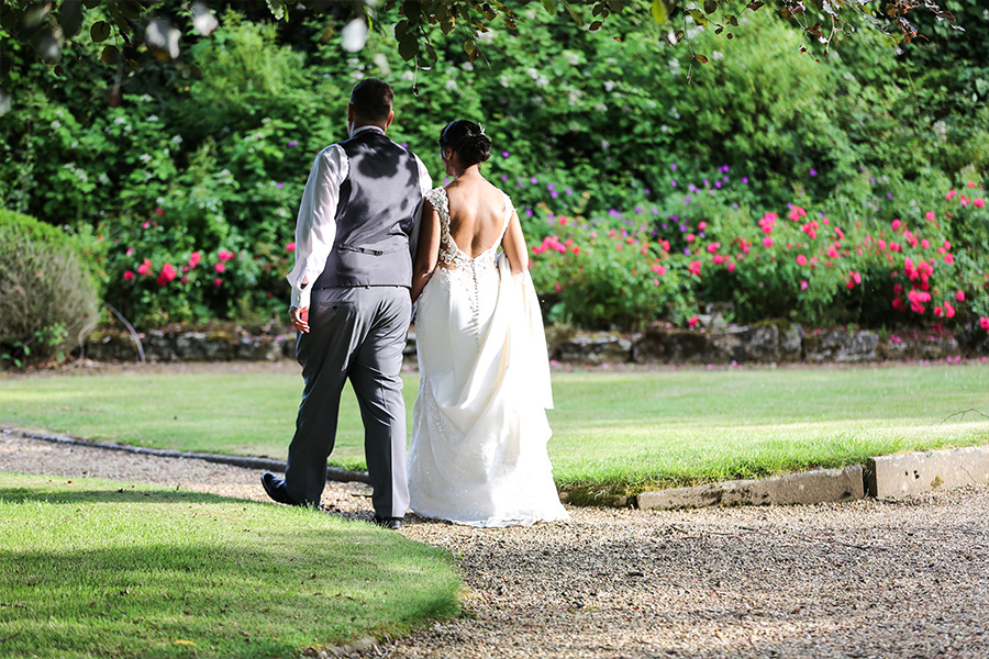 Bride and groom walking through gardens at The Orangery Suite Dorset wedding venue