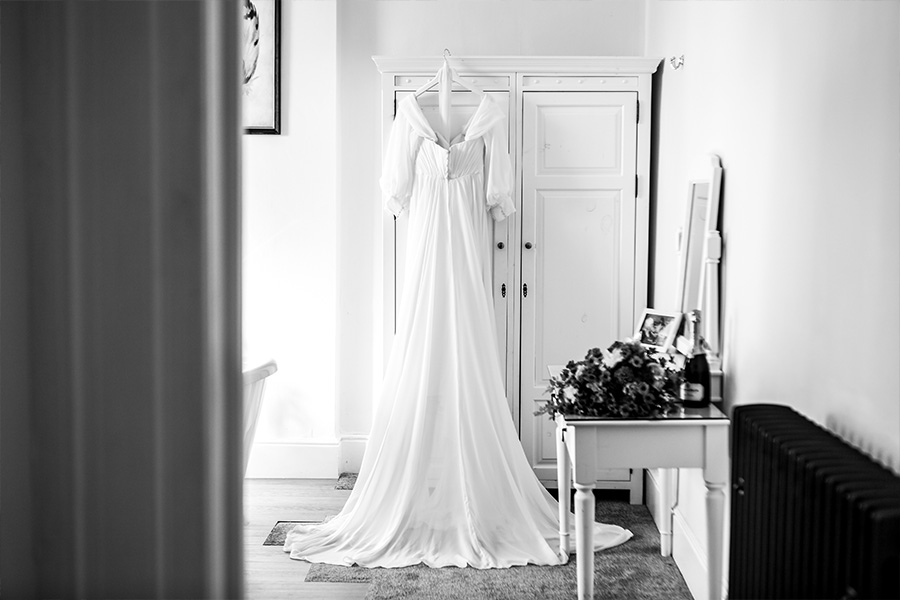Wedding dress hanging in a bridal preparation room at Bartley Lodge, Hampshire.