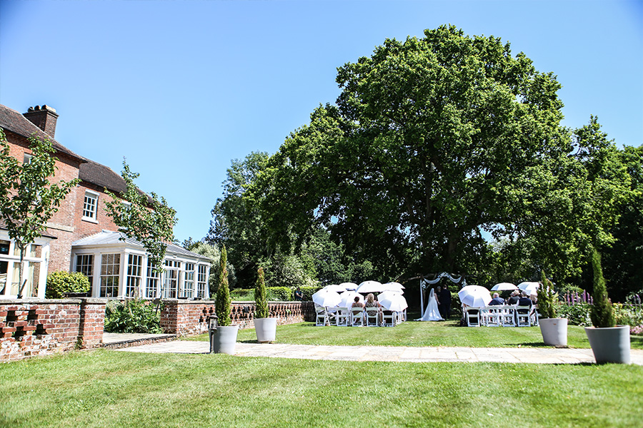 Outdoor wedding ceremony in the gardens of Bartley Lodge, Hampshire.
