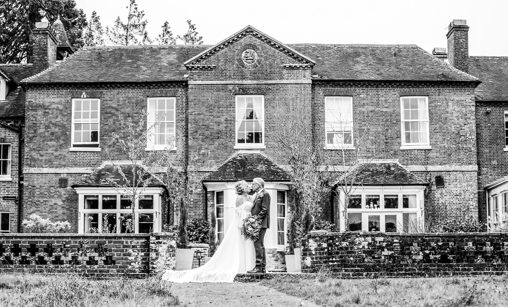Bride and groom standing outside Bartley Lodge wedding venue in the New Forest, Hampshire.