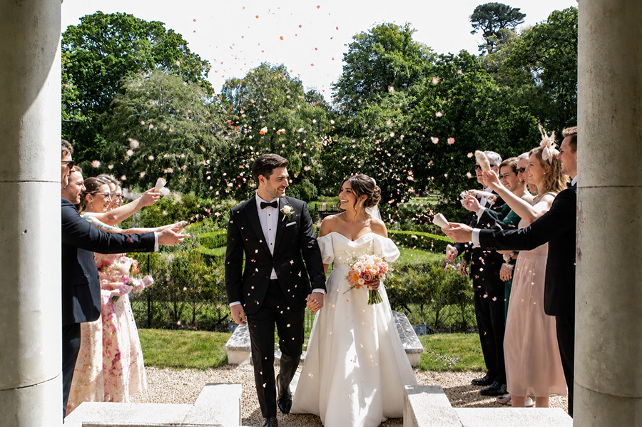 Bride and groom celebrating a confetti moment at Efford Park Manor, a luxury wedding venue in Hampshire.