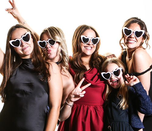 photo-booth-fun-wedding-guests-heart-sunglasses Wedding guests enjoying the Bridesparks photo booth wearing heart shaped sunglasses and posing for fun group photographs at a wedding reception.