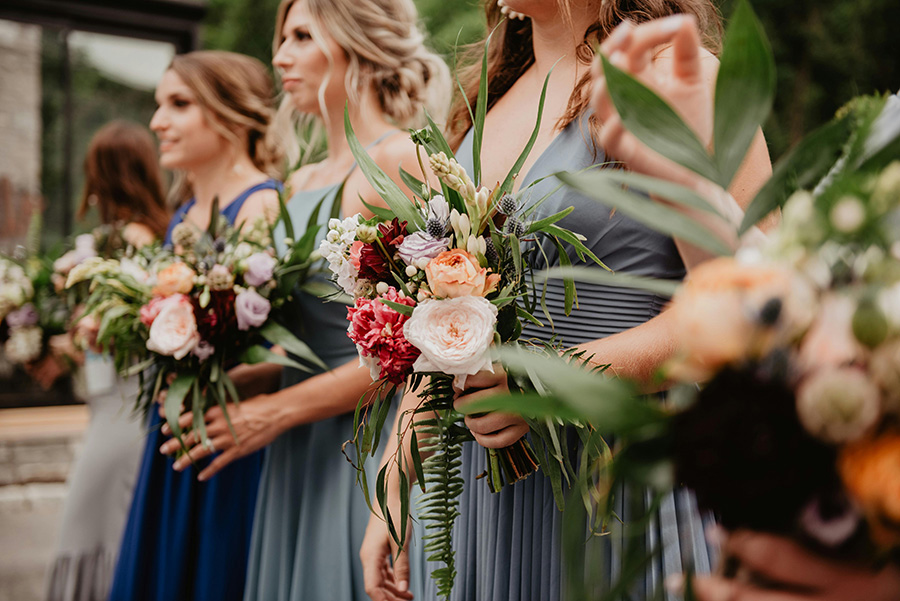 Bridesmaids holding elegant wedding bouquets with seasonal flowers at a Wiltshire wedding venue.