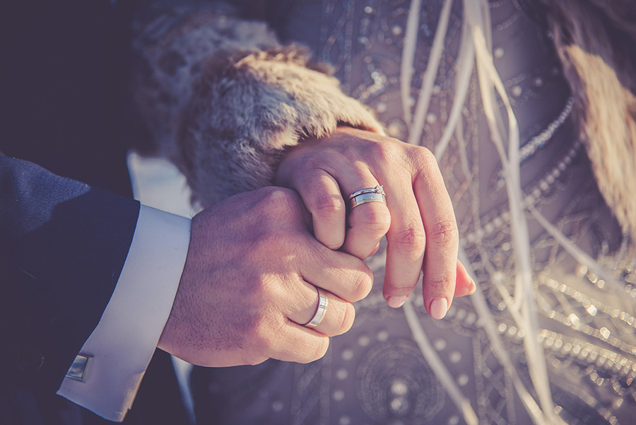 Couple holding hands and showing their wedding rings in Wiltshire