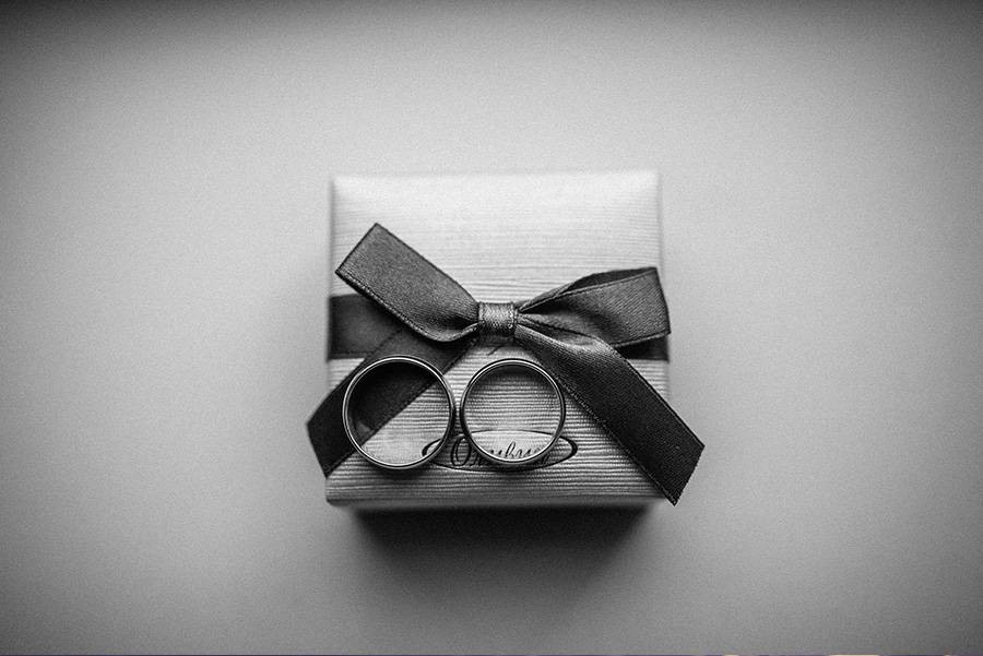 Two wedding rings displayed on a ribboned ring box